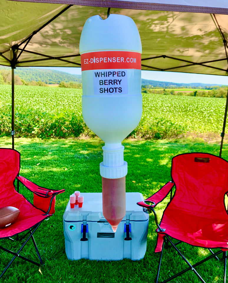 white plastic shot dispenser hanging from a pop up tent at a backyard party